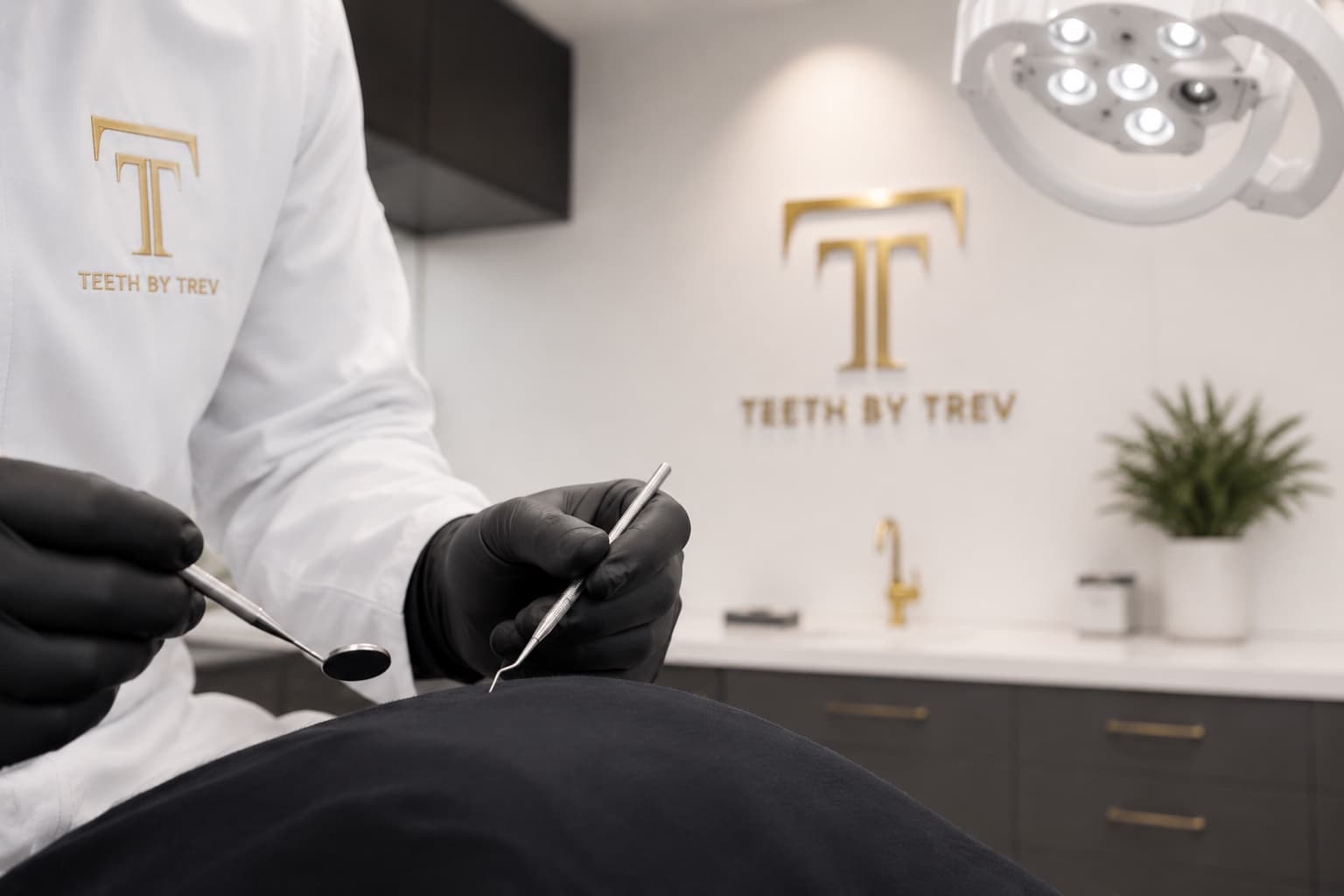 Dr. Trevor J. Thomas holding dental instruments in the Teeth by Trev operatory